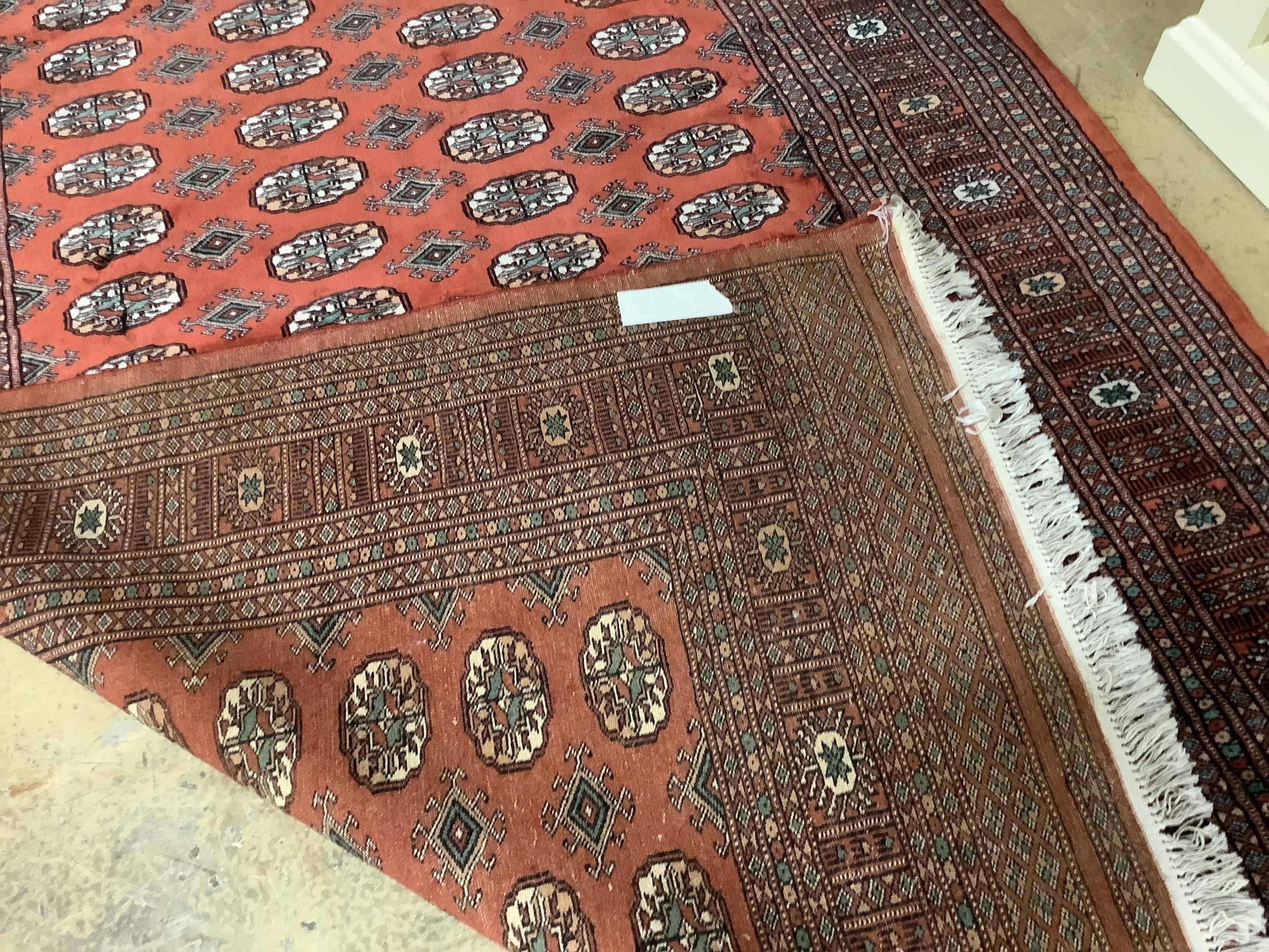 A Bokhara red ground rug, 240 x 155cm